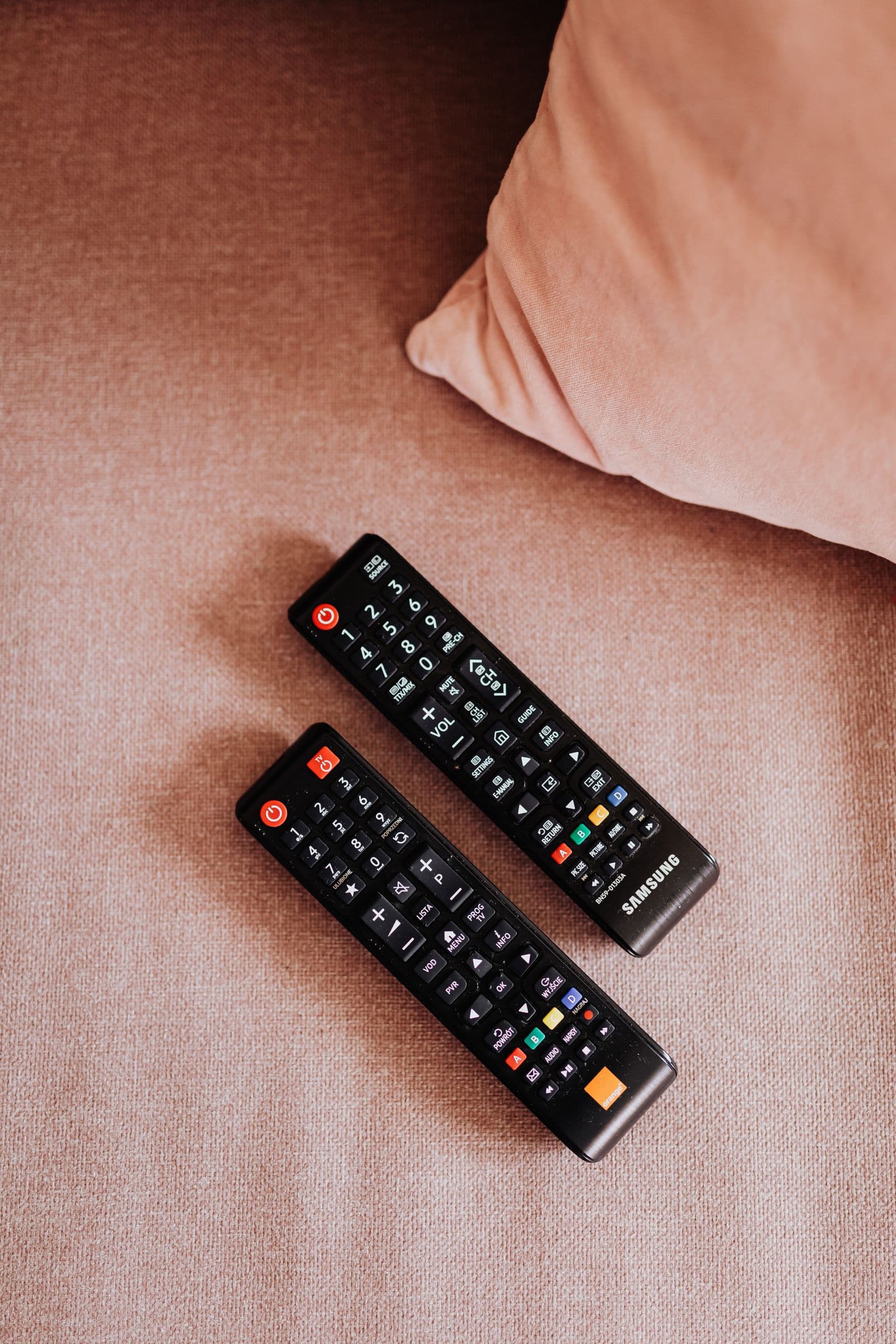 Télécommandes Samsung sur un canapé — installer une IPTV sur Samsung Smart TV Tizen