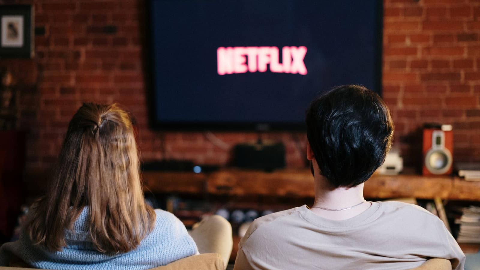 Télécommande Android TV pointée vers un téléviseur 4K affichant une grille EPG IPTV