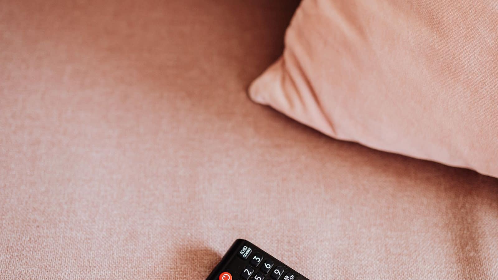 Télécommande TV sur canapé — choisir un abonnement IPTV pas cher en France 2026