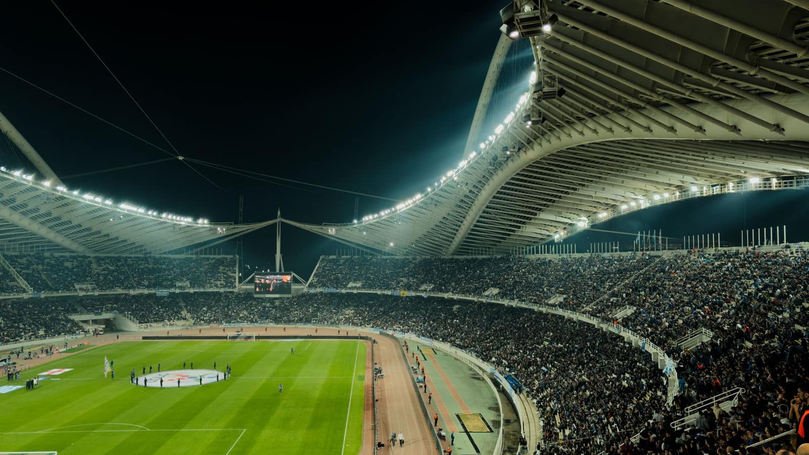 Stade de football illuminé en soirée pour un match du championnat français diffusé en IPTV